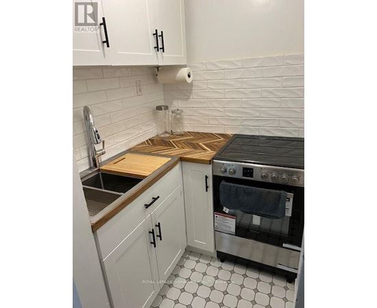 A kitchen with white cabinets and a black stove top oven.