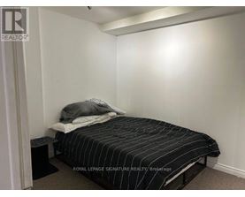 A bedroom with a bed and a nightstand.