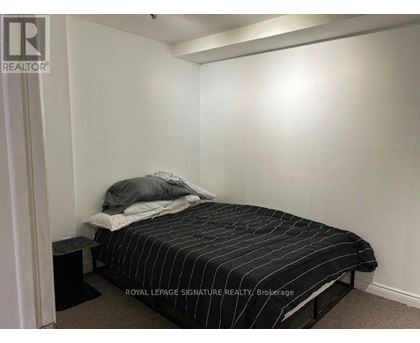 A bedroom with a bed and a nightstand.