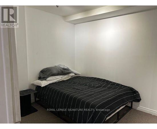 A bedroom with a bed and a nightstand.
