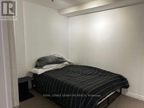A bedroom with a bed and a nightstand.