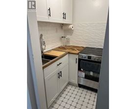 A kitchen with white cabinets and a black and white floor.