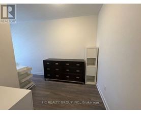 A room with a black dresser and a white cabinet.
