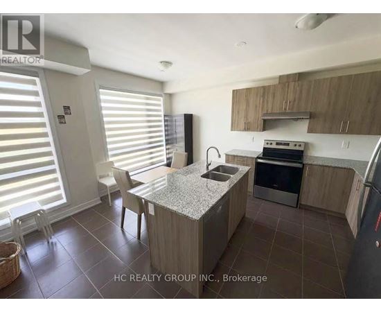 A kitchen with a table and chairs in front of a window with blinds.