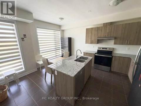 A kitchen with a table and chairs in front of a window with blinds.