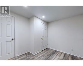 A white room with two doors and a wooden floor.