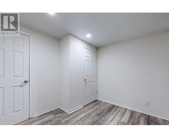 A white room with two doors and a wooden floor.