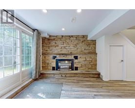 A stone fireplace is built into a wall in a spacious room.