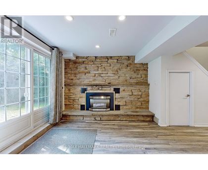A stone fireplace is built into a wall in a spacious room.