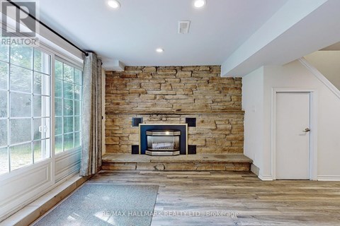 A stone fireplace is built into a wall in a spacious room.