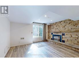 A room with a stone wall and a fireplace.