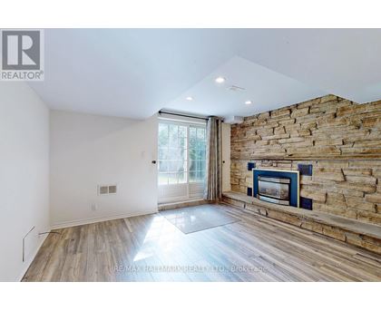 A room with a stone wall and a fireplace.
