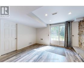 A spacious room with a sliding glass door leading to a balcony.