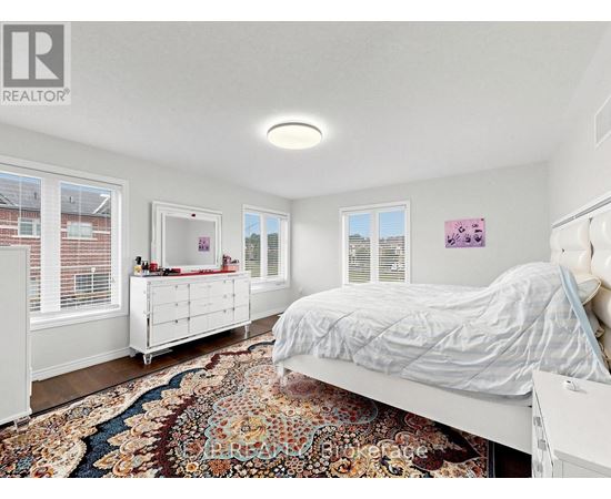 A bedroom with a large bed and a rug on the floor.