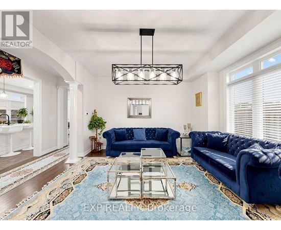 A living room with a blue couch and a glass coffee table.