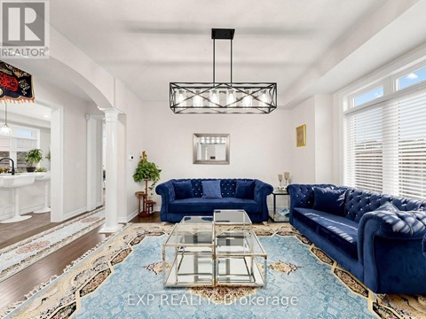 A living room with a blue couch and a glass coffee table.