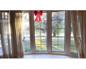 A room with a large window and a red bow on the window.
