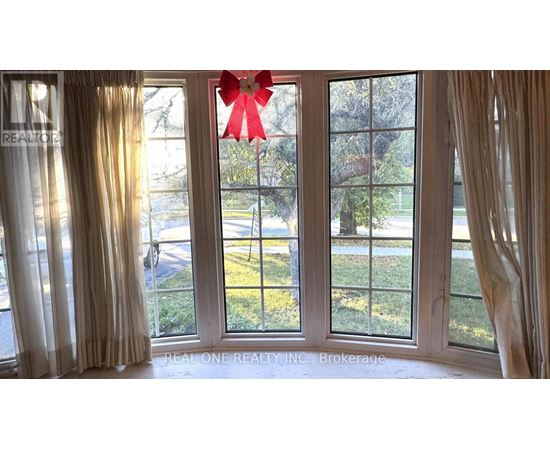 A room with a large window and a red bow on the window.