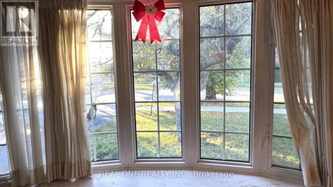 A room with a large window and a red bow on the window.