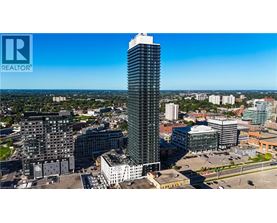 A tall building with a glass facade stands out in a cityscape.