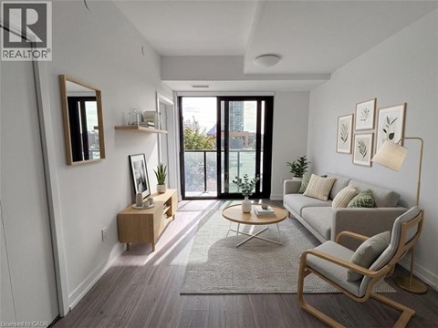 A living room with a grey couch, a wooden chair, and a coffee table.