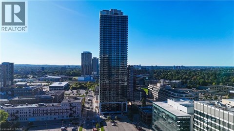 A cityscape with a tall building in the foreground and a clear blue sky above.