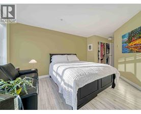 A bedroom with a large bed and a painting on the wall.