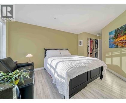 A bedroom with a large bed and a painting on the wall.