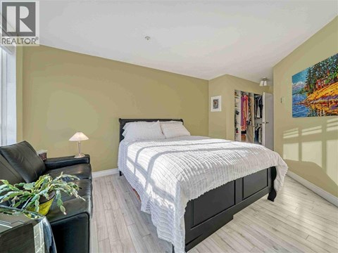 A bedroom with a large bed and a painting on the wall.
