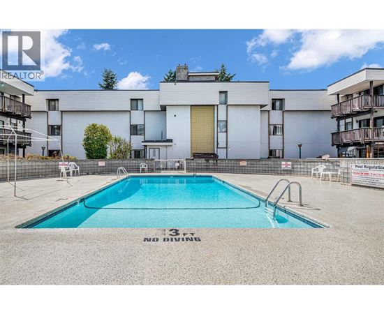 A swimming pool in front of a building with a sign that says "No Diving".