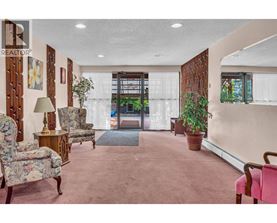 A living room with a pink carpet and a wooden door.