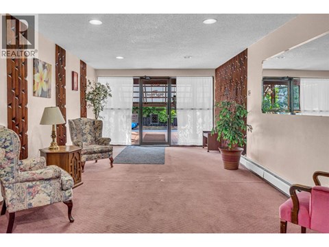 A living room with a pink carpet and a wooden door.