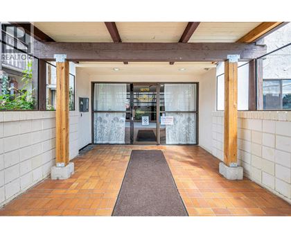 A hallway with a brown carpet and white walls.