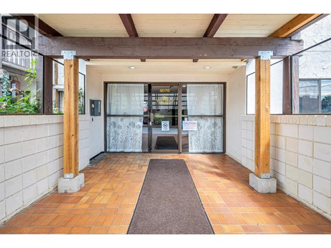 A hallway with a brown carpet and white walls.