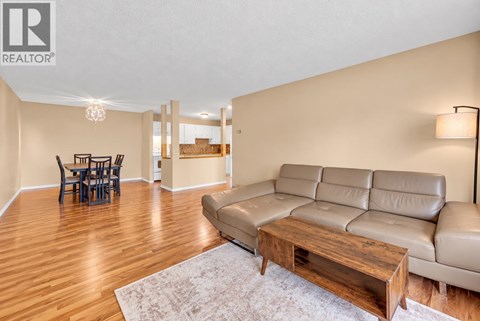 A living room with a leather couch and a wooden coffee table.