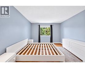 A bedroom with a bed, dresser, and window.