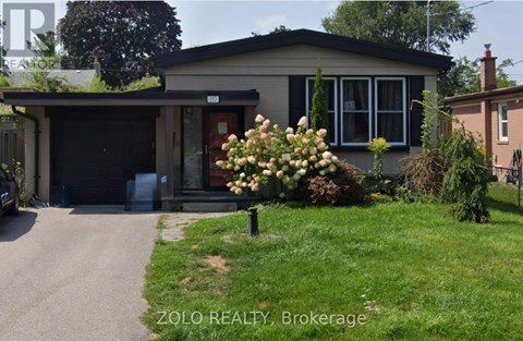 A house with a garage and a flower bed in front.