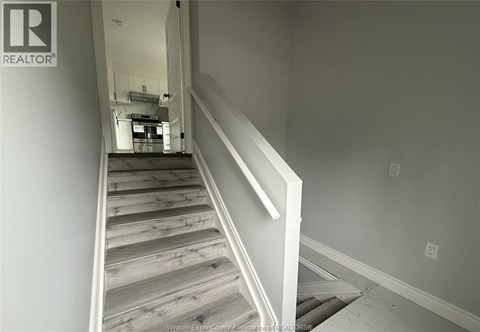 A staircase with wooden steps and white railings.