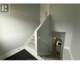 A stairway with a black carpet on the floor.