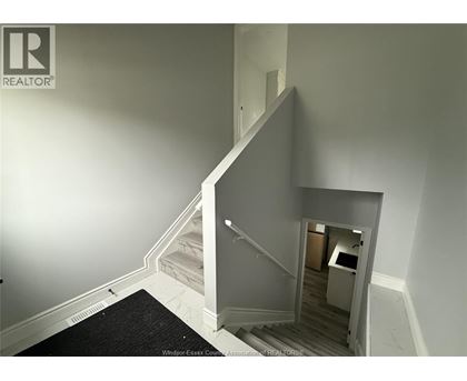 A stairway with a black carpet on the floor.