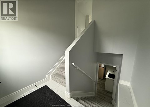 A stairway with a black carpet on the floor.