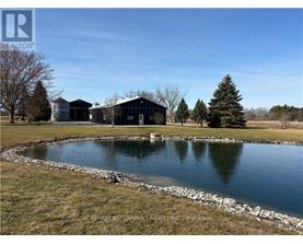 A pond in front of a building with the logo REALTOR on the top left.