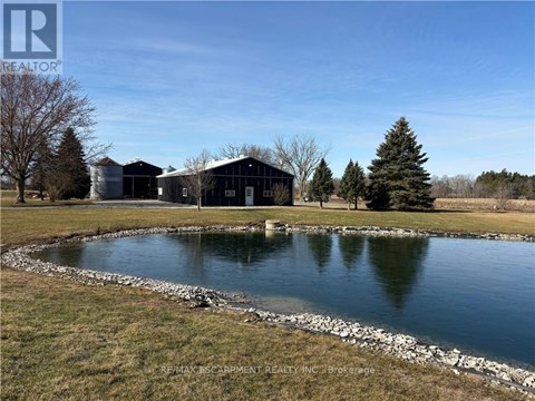 A pond in front of a building with the logo REALTOR on the top left.