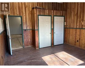 A room with wooden walls and a white door.