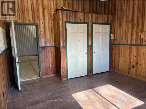 A room with wooden walls and a white door.