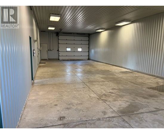 A large, empty warehouse space with a concrete floor and metal walls.