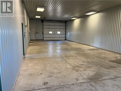 A large, empty warehouse space with a concrete floor and metal walls.