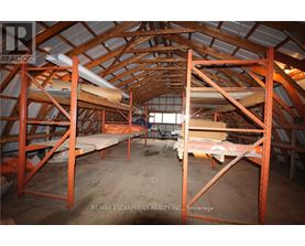 A large, empty attic space with wooden beams and a concrete floor.