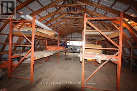 A large, empty attic space with wooden beams and a concrete floor.