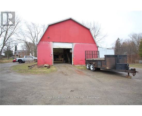 A red barn with a truck parked in front of it.